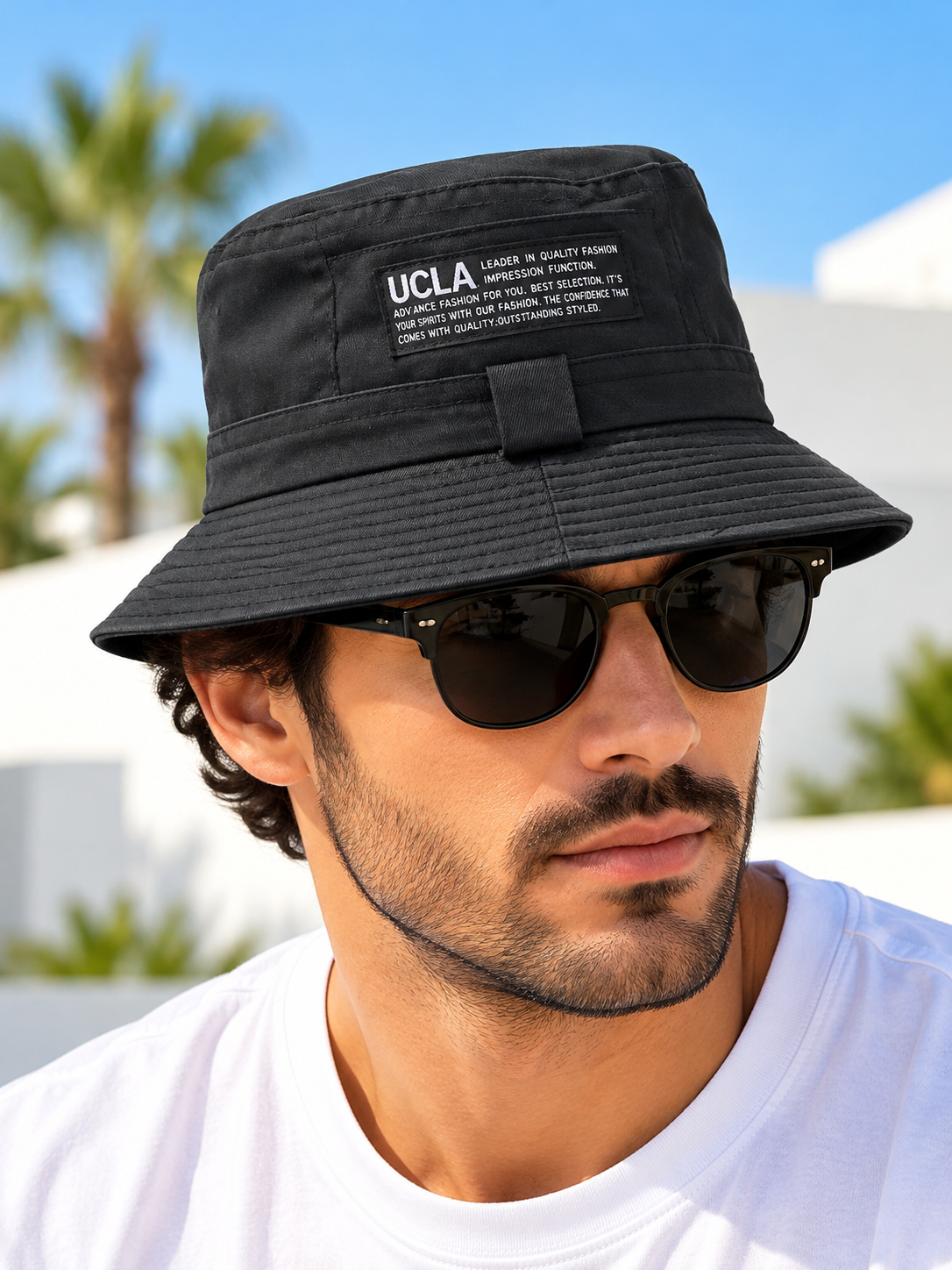 Black UCLA labelled bucket hat worn by male model with sunglasses