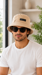 Beige UCLA bucket hat worn by male model