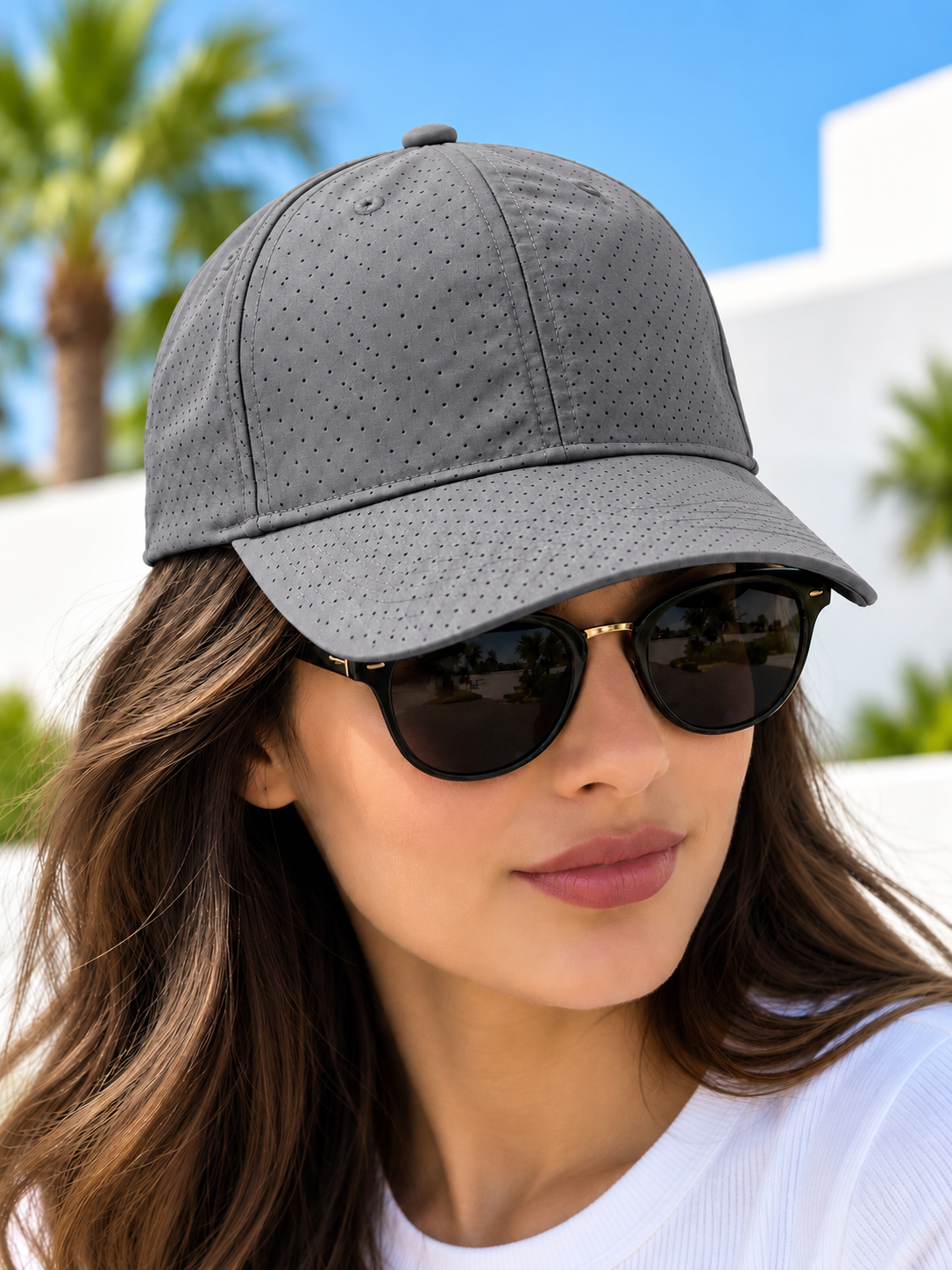 Grey perforated baseball cap worn by female model with sunglasses