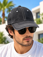 Men's black baseball cap with white contrast stitching and curved peak