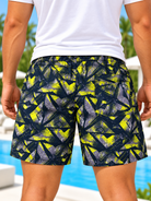 side view of men's navy and neon yellow abstract print shorts