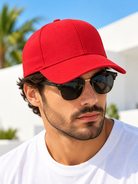 Bright red plain baseball cap on male model wearing sunglasses